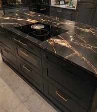 Black kitchen island with gold-veined worktop